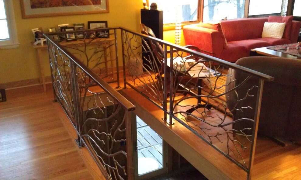 Steel stair railing with branch-shaped balusters around a stair opening